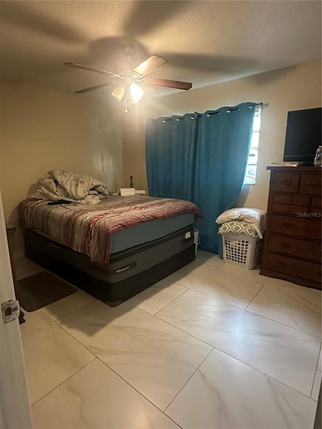 bedroom featuring a ceiling fan and a textured ceiling