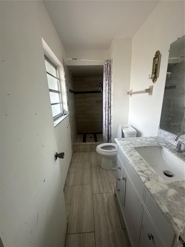 full bath with a shower stall, toilet, and vanity