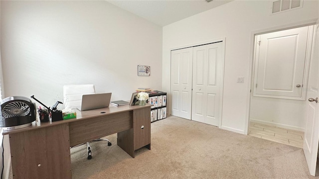 office featuring baseboards, visible vents, and light carpet