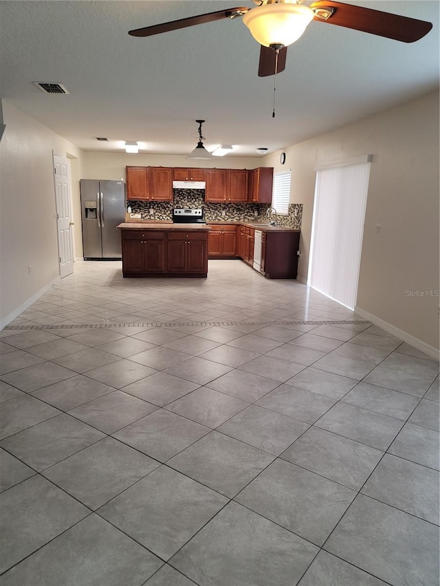 kitchen with tasteful backsplash, visible vents, a kitchen island, appliances with stainless steel finishes, and a ceiling fan