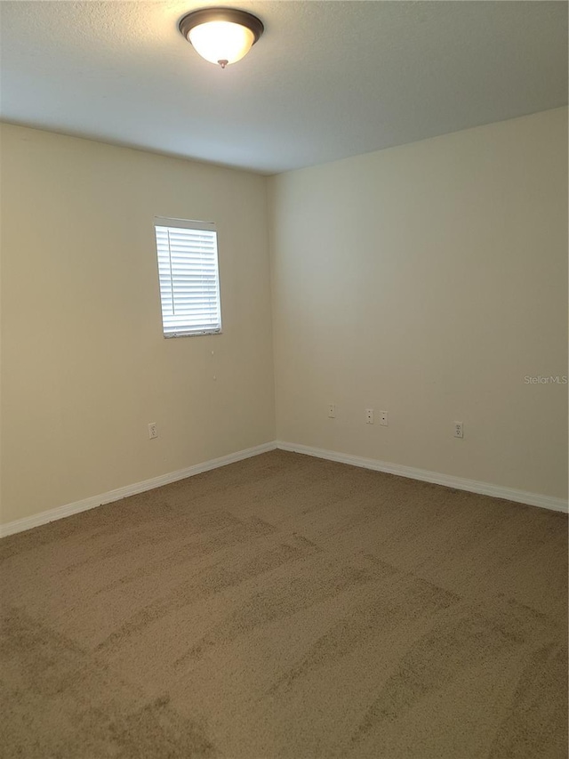 empty room with carpet and baseboards