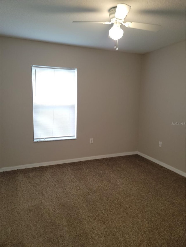 carpeted spare room with baseboards and a ceiling fan