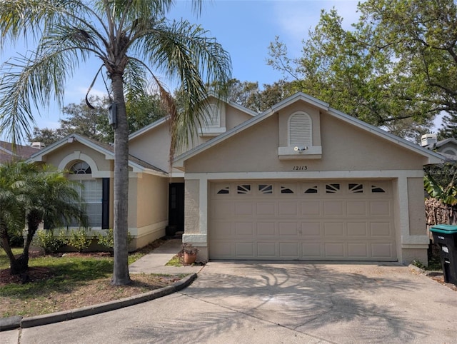 view of front facade with stucco siding, an attached garage, and concrete driveway