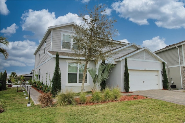 view of front of home featuring decorative driveway, a front yard, an attached garage, and stucco siding