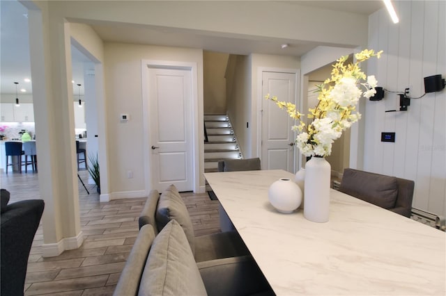 dining area with stairway, baseboards, and wood finish floors