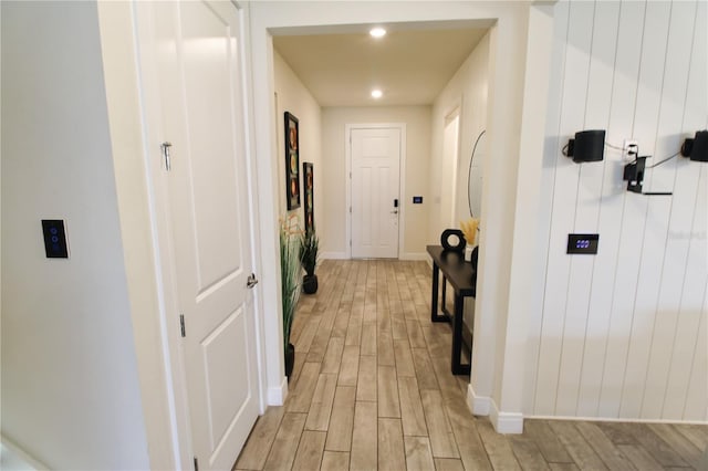 corridor featuring recessed lighting, light wood-type flooring, and baseboards