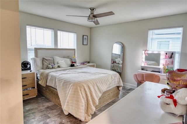 bedroom with multiple windows, baseboards, ceiling fan, and wood finished floors