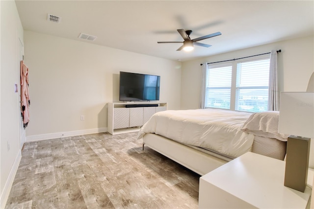 bedroom with visible vents, a ceiling fan, light wood-type flooring, and baseboards