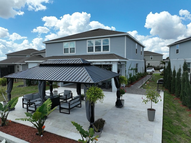 rear view of house featuring a patio, a standing seam roof, a shingled roof, a gazebo, and metal roof