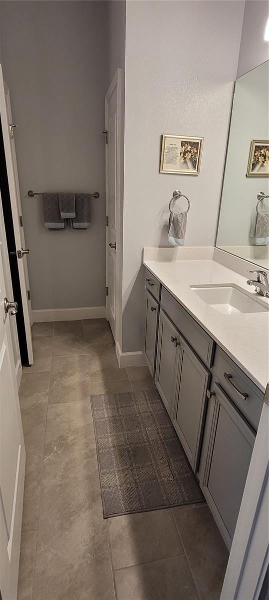 bathroom featuring tile patterned flooring, vanity, and baseboards