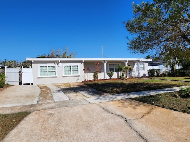 ranch-style home with stucco siding, a front yard, and fence