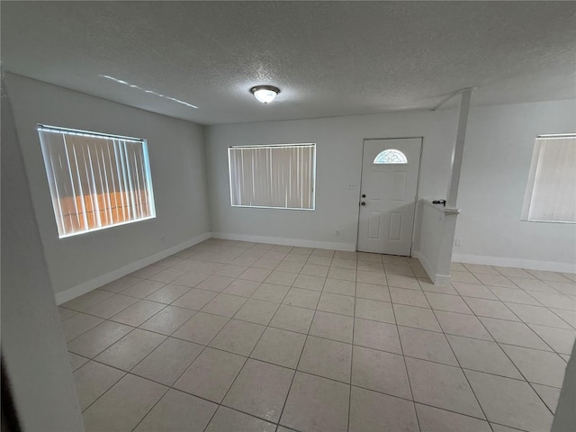 foyer with baseboards and a textured ceiling