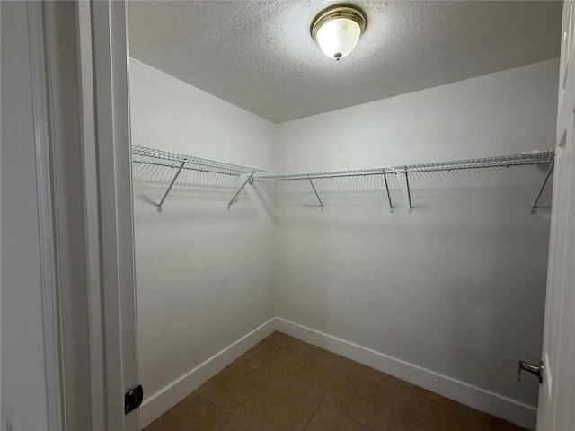 spacious closet with dark tile patterned floors