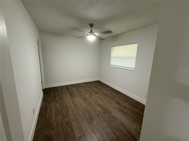 unfurnished room featuring baseboards, a textured ceiling, dark wood-style floors, and a ceiling fan