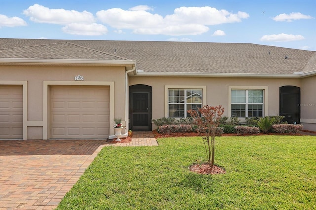 view of front of property featuring a front yard, driveway, roof with shingles, stucco siding, and a garage