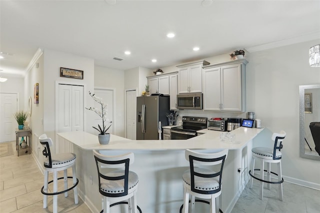 kitchen featuring stainless steel appliances, a kitchen bar, crown molding, and light countertops