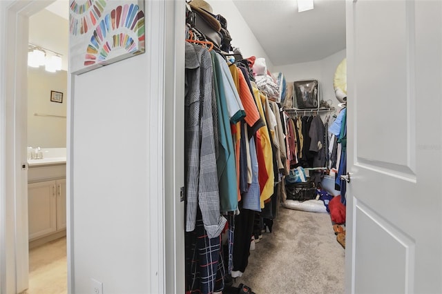 walk in closet with a sink and carpet floors