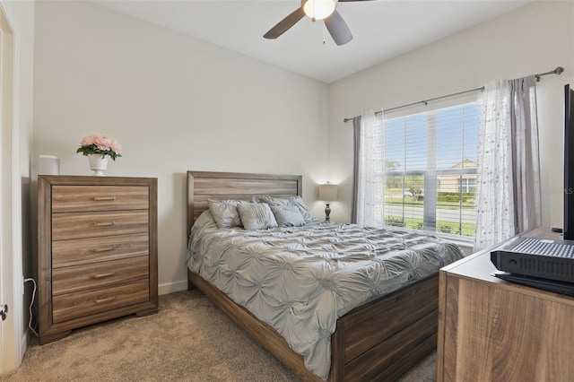 bedroom featuring light colored carpet, baseboards, and ceiling fan