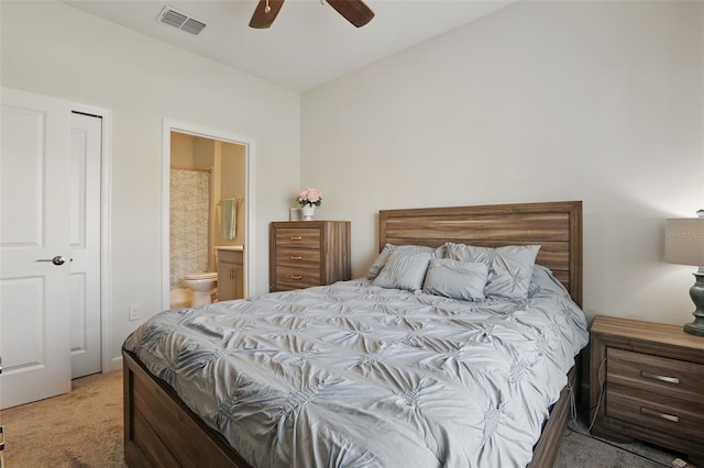 bedroom with visible vents, light carpet, ensuite bath, and a ceiling fan