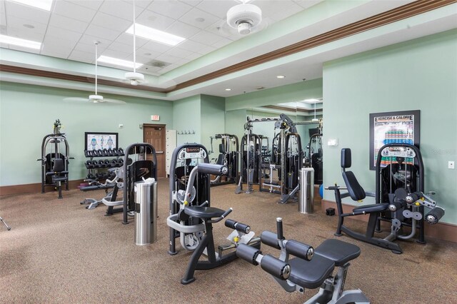 workout area featuring a tray ceiling, a paneled ceiling, and baseboards