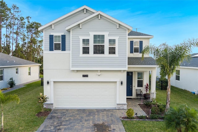 view of front of property with decorative driveway, a front lawn, and stucco siding