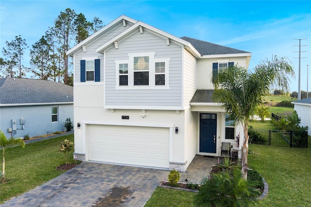 traditional-style home with decorative driveway, fence, roof with shingles, an attached garage, and a front yard