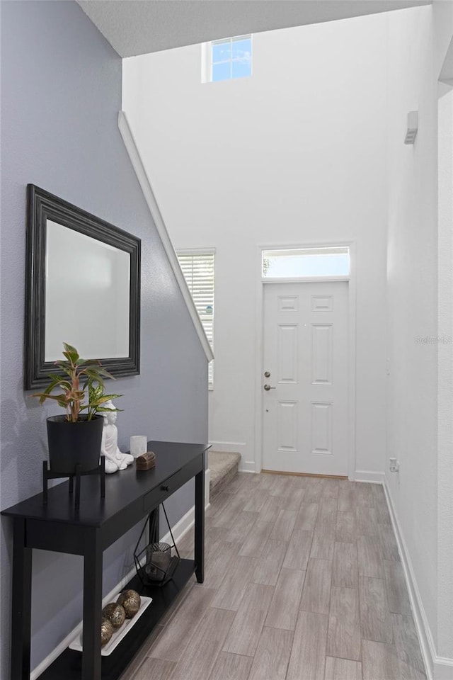 entrance foyer featuring a wealth of natural light, stairs, and light wood-style floors