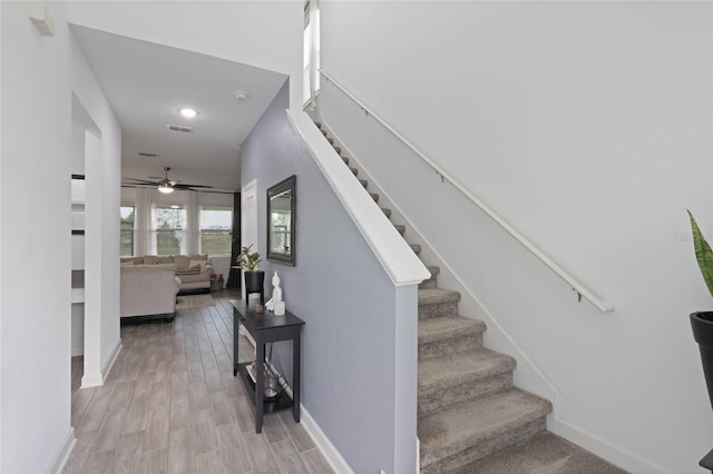 stairs with visible vents, baseboards, and wood finished floors