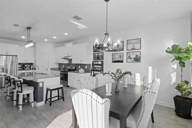 dining area with recessed lighting, visible vents, light wood-style floors, and a chandelier