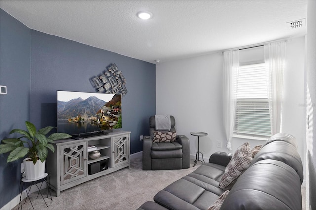 carpeted living room with visible vents and a textured ceiling