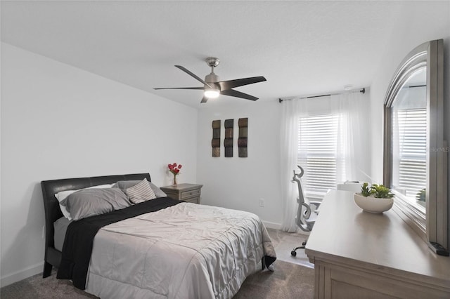 carpeted bedroom featuring baseboards and a ceiling fan