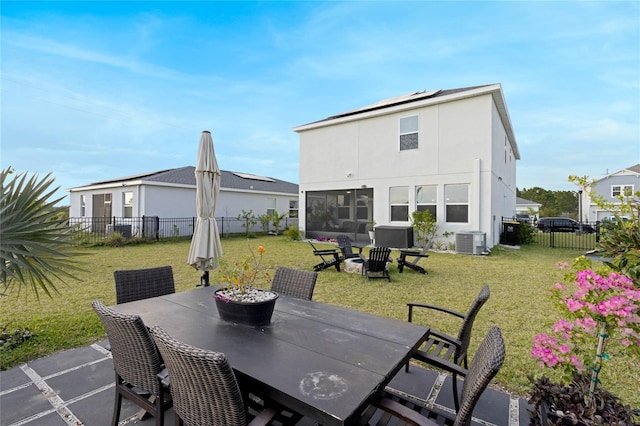 exterior space with central air condition unit, stucco siding, a yard, a fenced backyard, and outdoor dining space