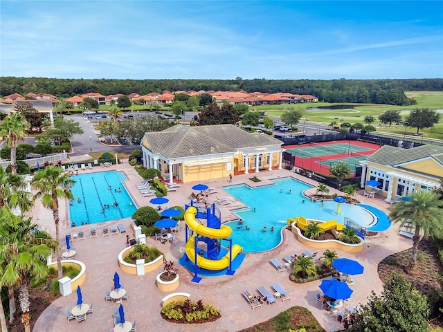 pool with a patio, fence, a water slide, and a water play area