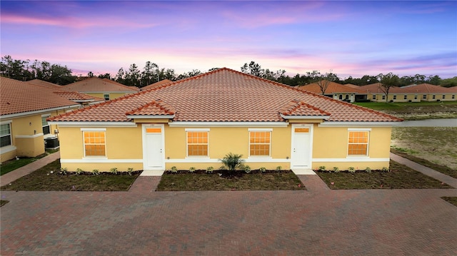 mediterranean / spanish house with a tile roof and stucco siding