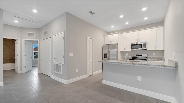 kitchen featuring stainless steel appliances, a peninsula, visible vents, and white cabinets