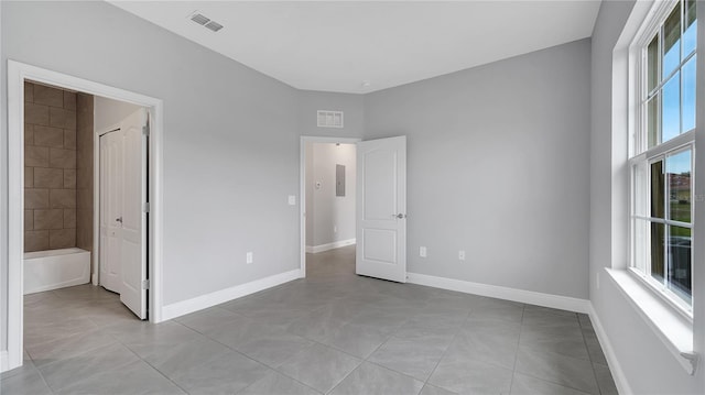 unfurnished bedroom with light tile patterned flooring, baseboards, and visible vents