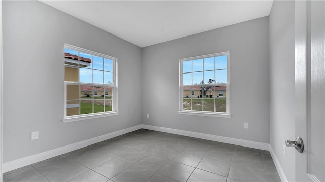 empty room with tile patterned floors and baseboards
