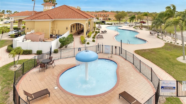 pool with fence, a patio, and a lawn