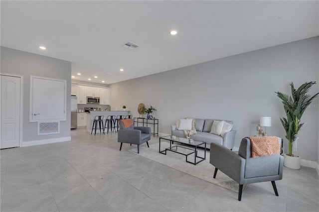 living area featuring visible vents, baseboards, and recessed lighting