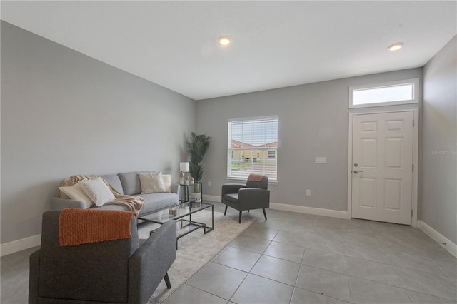living room featuring light tile patterned floors, baseboards, and plenty of natural light