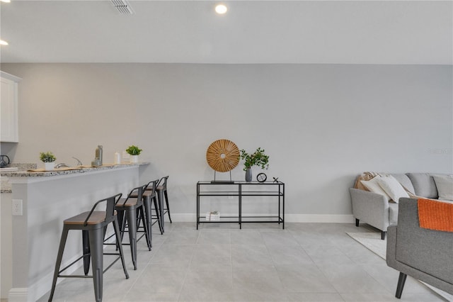interior space featuring visible vents, baseboards, recessed lighting, and light tile patterned floors