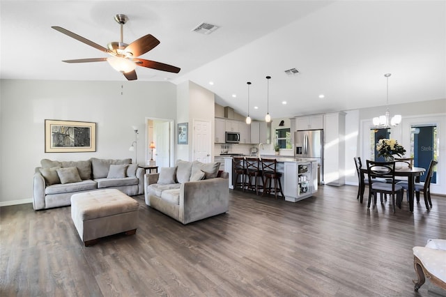 living room with dark wood-type flooring, ceiling fan with notable chandelier, and visible vents