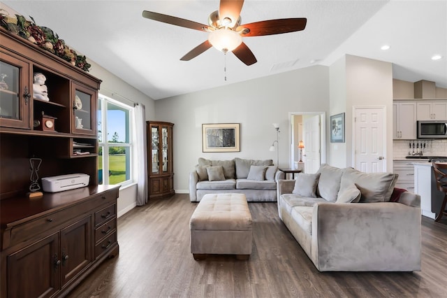 living room with visible vents, ceiling fan, baseboards, dark wood finished floors, and lofted ceiling