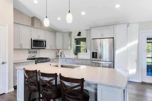 kitchen featuring tasteful backsplash, a healthy amount of sunlight, lofted ceiling, stainless steel appliances, and a sink