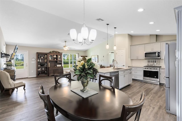 dining space with wood finished floors, visible vents, baseboards, recessed lighting, and vaulted ceiling