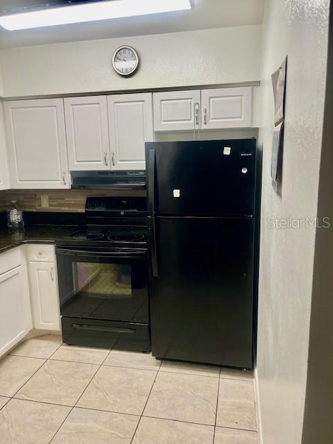 kitchen featuring under cabinet range hood, white cabinets, and black appliances