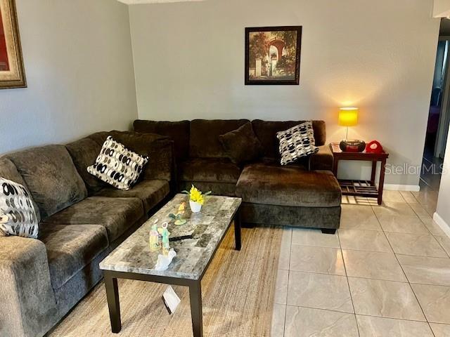 living room featuring baseboards and light tile patterned flooring