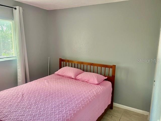 bedroom featuring tile patterned floors and baseboards