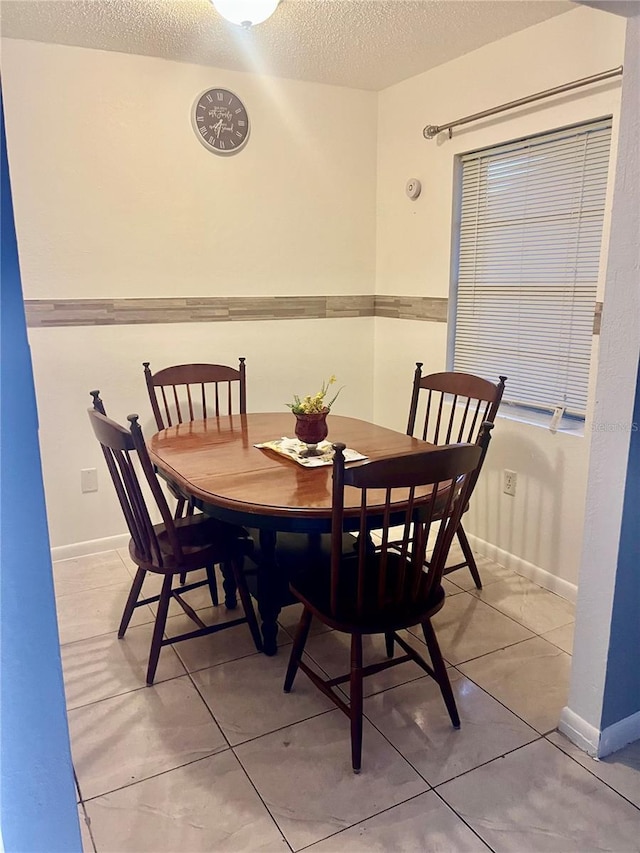 731 Wyman Ct Unit 731-A, Orlando, FL 32809 - dining room featuring a textured ceiling, light tile patterned floors, and baseboards