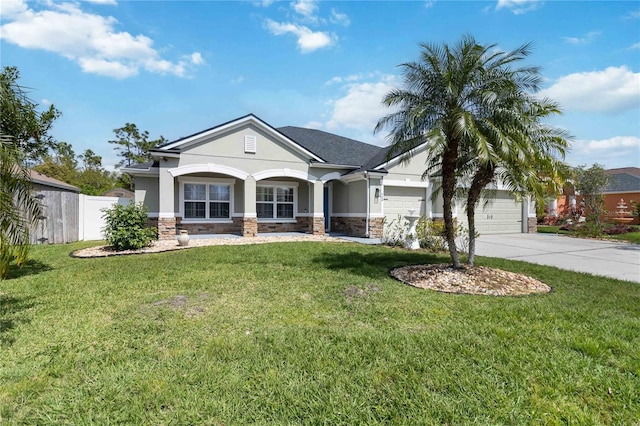 view of front of property featuring a front lawn, fence, stone siding, and stucco siding